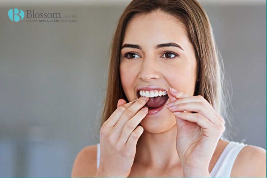 Sử dụng chỉ nha khoa ít nhất một lần mỗi ngày hoặc súc miệng bằng nước muối giúp răng sạch sẽ.